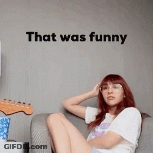 A Woman Is Sitting On A Couch In Front Of A Wall With The Words `` That Was Funny '' . GIF