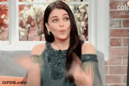 A Woman Is Sitting On A Couch In Front Of A Window With The Word Colo On The Bottom GIF