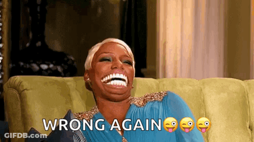 A Woman Is Sitting On A Couch Laughing With The Words Wrong Again Written Above Her . GIF