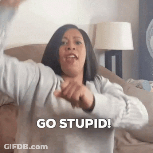 A Woman Is Sitting On A Couch Making A Funny Face And Saying `` Go Stupid ! '' GIF