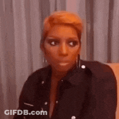 A Woman Is Sitting On A Couch Making A Funny Face . GIF