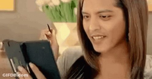 A Woman Is Sitting On A Couch Using A Tablet Computer While Holding A Pen . GIF