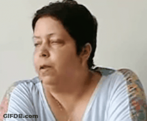 A Woman Is Sitting On A Couch With Her Eyes Closed And Her Mouth Open . GIF
