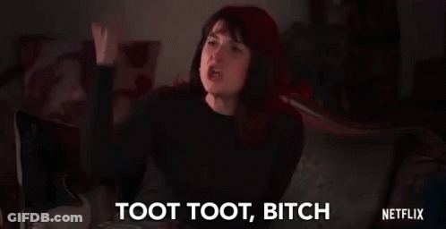 A Woman Is Sitting On A Couch With Her Fist In The Air And Saying Toot Toot Bitch . GIF