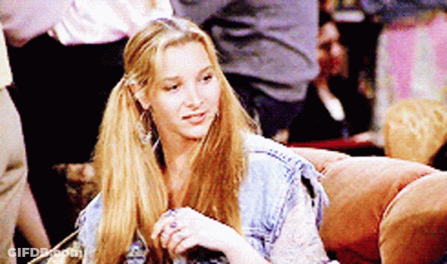 A Woman Is Sitting On A Couch With Her Hair In Pigtails GIF