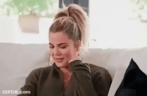 A Woman Is Sitting On A Couch With Her Hand On Her Face And Crying . GIF