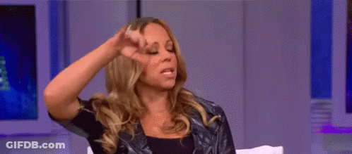 A Woman Is Sitting On A Couch With Her Hand On Her Head . GIF