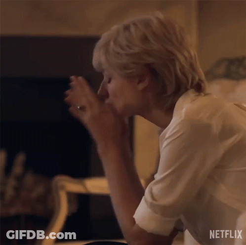 A Woman Is Sitting On A Couch With Her Head On Her Knees . GIF