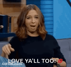 A Woman Is Sitting On A Couch With Her Mouth Open And A Kiss On Her Cheek . GIF