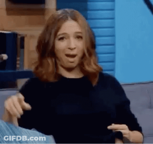 A Woman Is Sitting On A Couch With Her Mouth Open And Making A Face . GIF