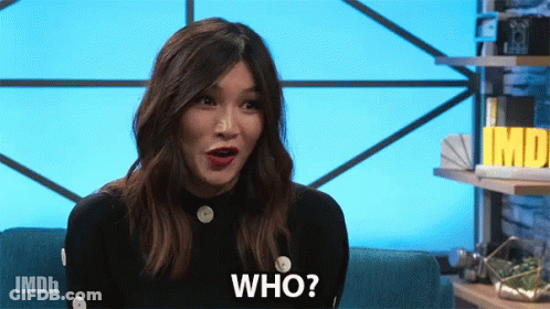 A Woman Is Sitting On A Couch With Her Mouth Open And Says Who GIF