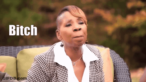 A Woman Is Sitting On A Couch With The Word Bitch Written In The Background GIF