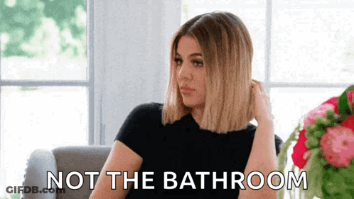 A Woman Is Sitting On A Couch With The Words Not The Bathroom Written On The Bottom . GIF