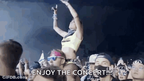 A Woman Is Sitting On A Man 'S Shoulders At A Concert Holding A Microphone . GIF