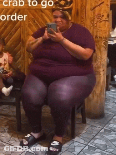 A Woman Is Sitting On A Stool Looking At Her Phone With The Words " Crab To Go Order " Written Above Her GIF