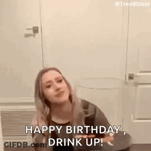 A Woman Is Sitting On A Toilet Holding A Glass Of Wine And Saying `` Happy Birthday , Drink Up '' . GIF
