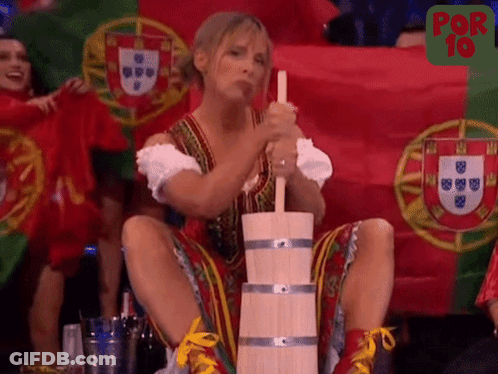 A Woman Is Sitting On A Wooden Barrel With A Flag In The Background GIF