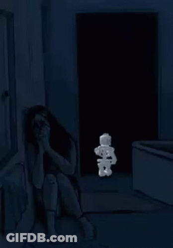 A Woman Is Sitting On The Floor In A Dark Room With A Stuffed Smurf . GIF