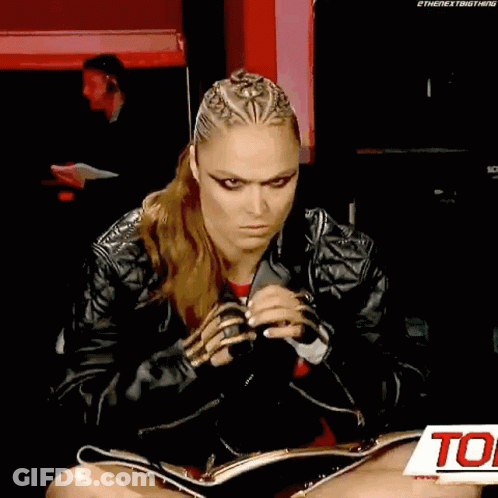 A Woman Is Sitting On The Floor With Her Legs Crossed And Holding A Microphone . GIF