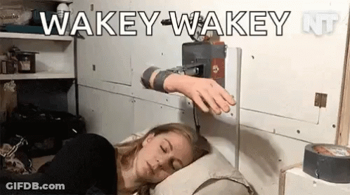 A Woman Is Sleeping In A Bed With A Machine On Her Arm That Says Wakey-Wakey . GIF