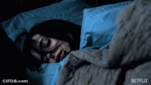A Woman Is Sleeping In A Bed With A Netflix Logo Behind Her GIF