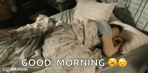 A Woman Is Sleeping In A Bed With The Words `` Good Morning '' Written On It . GIF