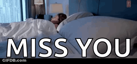 A Woman Is Sleeping In A Bed With The Words Miss You Written Above Her GIF
