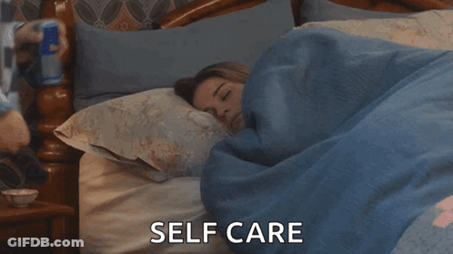 A Woman Is Sleeping In A Bed With The Words Self Care Written Above Her GIF