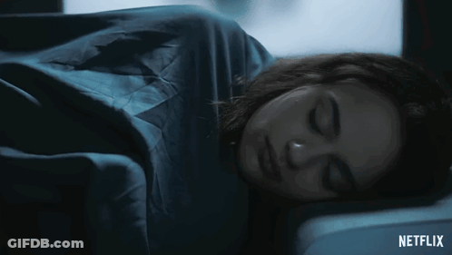 A Woman Is Sleeping In A Dark Room With A Netflix Logo In The Corner GIF