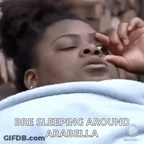 A Woman Is Sleeping In Bed With Her Eyes Closed And Her Hand On Her Face . GIF