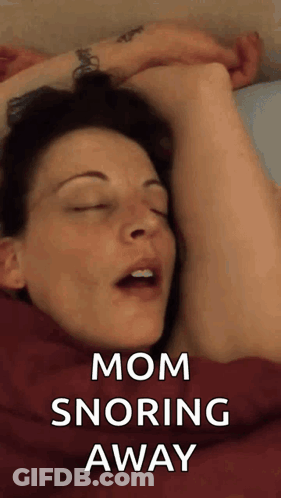 A Woman Is Sleeping In Bed With Her Eyes Closed And The Words Mom Snoring Away Above Her . GIF