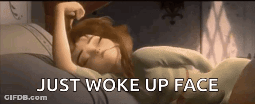 A Woman Is Sleeping In Bed With The Words `` Just Woke Up Face '' Written On The Bottom . GIF