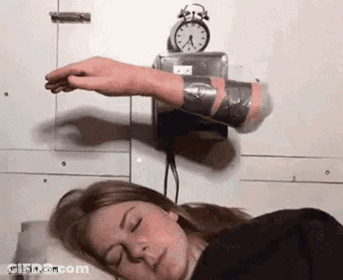 A Woman Is Sleeping In Front Of An Alarm Clock And A Hand Is Sticking Out Of It GIF