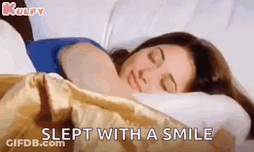 A Woman Is Sleeping With A Smile On Her Face . GIF