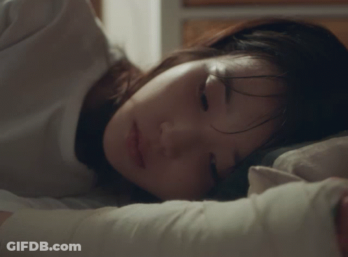 A Woman Is Sleeping With Her Eyes Closed And Her Hair Covering Her Face GIF