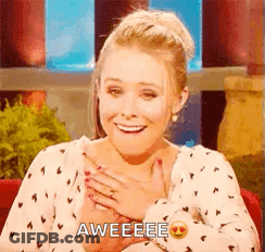 A Woman Is Smiling And Holding Her Hand To Her Chest While Wearing A Polka Dot Shirt . GIF