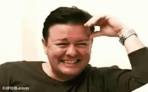 A Woman Is Smiling And Laughing While Holding Her Hand To Her Forehead . GIF