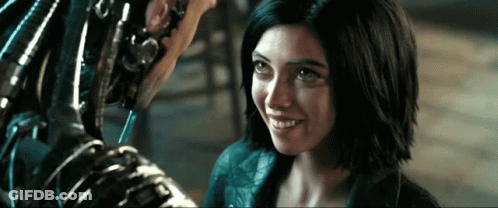 A Woman Is Smiling And Looking At A Robot GIF