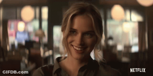 A Woman Is Smiling And Looking At The Camera In A Blurry Photo From Netflix . GIF
