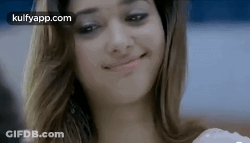 A Woman Is Smiling And Making A Funny Face . GIF
