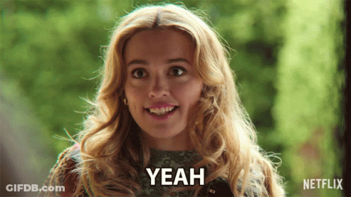 A Woman Is Smiling And Says Yeah In Front Of A Green Background GIF