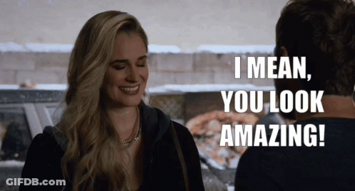 A Woman Is Smiling And Talking To A Man Who Says I Mean You Look Amazing GIF