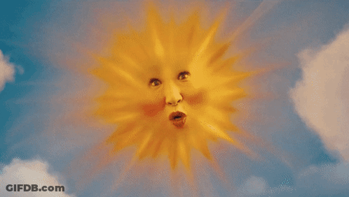 A Woman Is Smiling In A Field Of Flowers With Smiley Clouds In The Background GIF