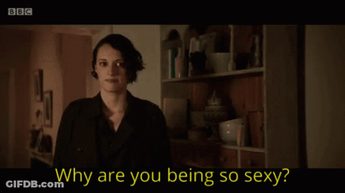 A Woman Is Smiling In Front Of A Bookshelf And The Words Why Are You Being So Sexy GIF