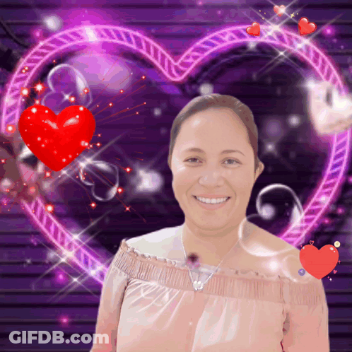A Woman Is Smiling In Front Of A Heart GIF