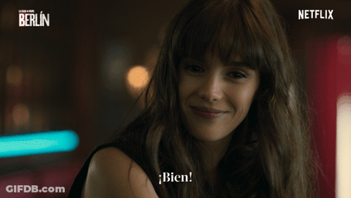 A Woman Is Smiling In Front Of A Netflix Banner GIF