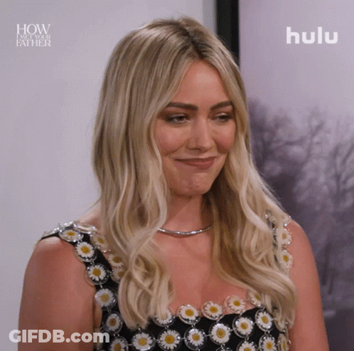 A Woman Is Smiling In Front Of A Picture That Says How I Met Your Father GIF