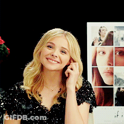 A Woman Is Smiling In Front Of A Poster For If GIF