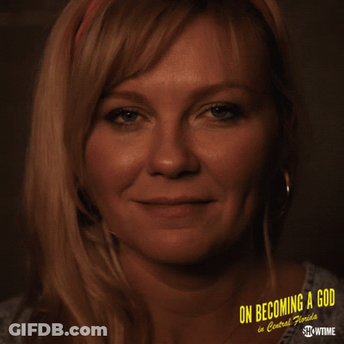 A Woman Is Smiling In Front Of A Poster That Says On Becoming A God In Central Florida GIF