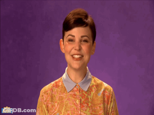 A Woman Is Smiling In Front Of A Purple Background That Says Shabbat Shalom On It GIF